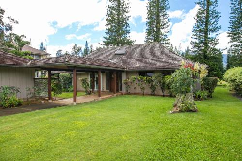 a house with a grass yard with a house at Hale Kamalani Mountain Villa and Golf Course Views in Princeville