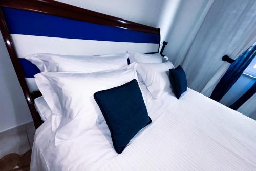 a white bed with a blue headboard and pillows at Casa Iside in Ladispoli