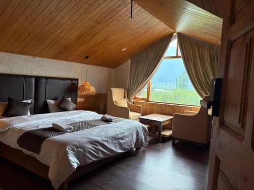Un dormitorio con una cama grande y una ventana grande. en Odbostays Manali, en Haripūr