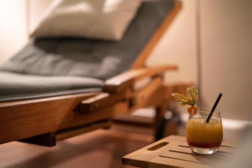 a drink on a table next to a bed at Ringhotel Villa Margarete in Waren