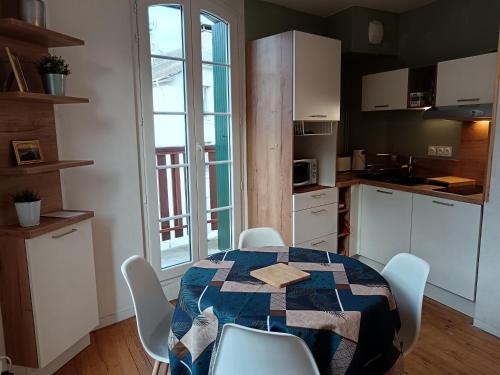 une cuisine avec une table et des chaises et une cuisine avec une fenêtre dans l'établissement T2 Coeur d' Argelès-Gazost, tout à pied, à Argelès-Gazost