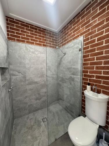 a bathroom with a toilet and a glass shower at Studio in CBD Bathurst in Bathurst