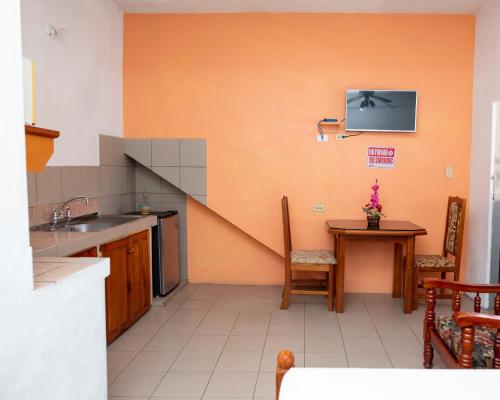 a kitchen with a sink and a table with a tv on the wall at Lesville Tobago in Canaan