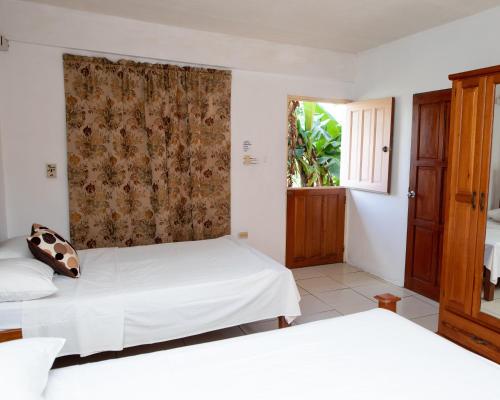 a bedroom with two beds and a window at Lesville Tobago in Canaan