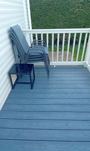 a blue chair sitting on the deck of a house at Happy Havan in Great Yarmouth