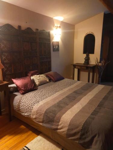 une chambre avec un grand lit avec des oreillers dessus dans l'établissement L'Amuse-Bouche, à Tresques