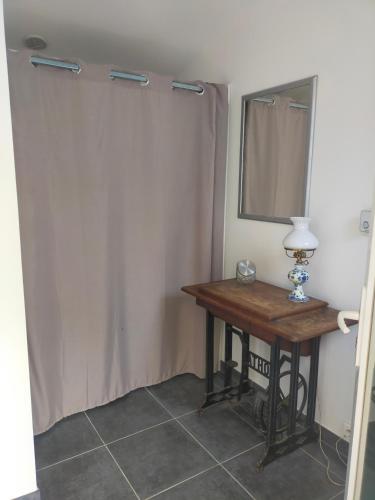 Cette chambre comprend une table et un miroir. dans l'établissement L'Amuse-Bouche, à Tresques