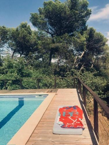 - une piscine avec un tapis sur une terrasse en bois dans l'établissement Villa avec patio et Pool House, à Saint-Nazaire