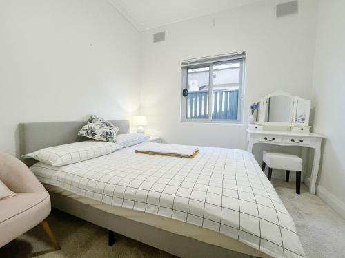 a white bedroom with a bed and a chair at Small Room B of South Bay Beach and AirPort in Sydney