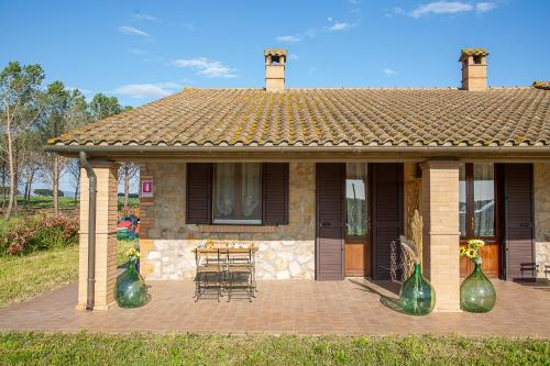 a house with two large green vases on a patio at Agriturismo Le Chiocciolaie Appartamento 1 - Appartamento 3 in Podere Cernaia