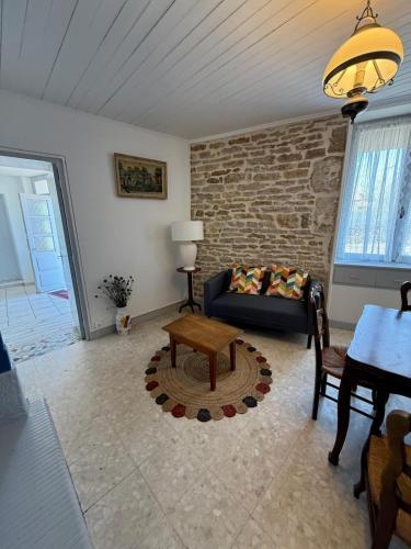 un salon avec un canapé et une table dans l'établissement La Parenthèse du Pailly Maison entière dans la campagne haute-marnaise, à Chalindrey