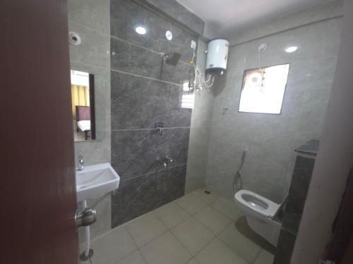a bathroom with a toilet and a sink at Blossom Service Apartment in Mysore