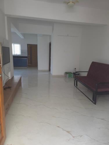 a living room with a couch and a television at Blossom Service Apartment in Mysore