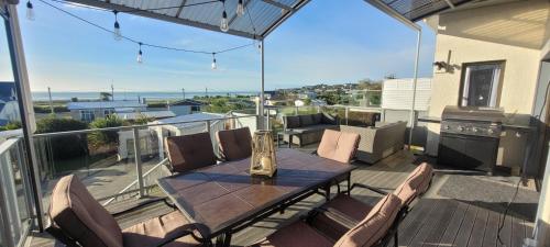 a patio with a table and chairs on a balcony at Seascape Retreat in Riverton