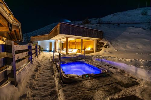a hot tub in the snow in front of a house at Chalet Stern in Vipiteno