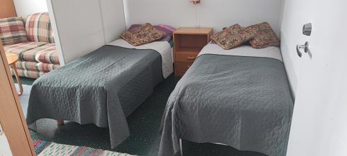a room with two beds and a couch at Kokonainen huoneisto olohuone makuualkovi ja keittiö ei suihkuh Iisalmen keskusta in Iisalmi