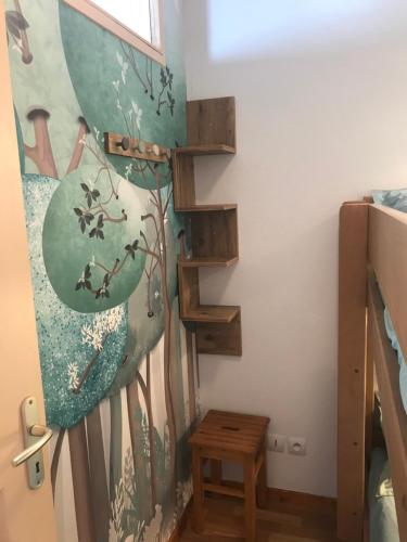 a staircase in a room with a painting of birds at Bel appartement 6pers lumineux - Arvieux - Parc naturel du Queyras in Arvieux