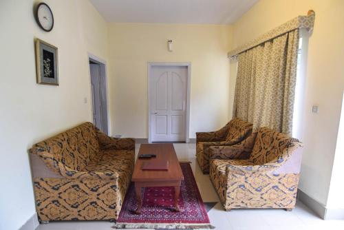 a living room with two couches and a coffee table at Parhena Cottages Bella Naran in Nārān