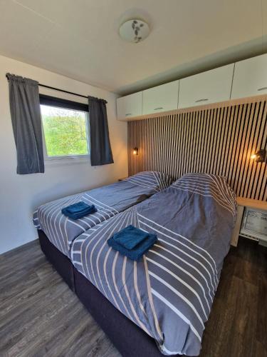 a bedroom with two beds with blue towels on them at Camping Wad noch Meer in Anna Paulowna