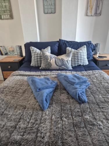 a blue bed with two pillows on top of it at Number 6 in St Austell