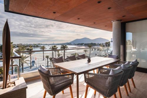 a dining room with a table and chairs and a view of the ocean at Luxury sea view Apartment in Puerto de Alcudia in Alcudia