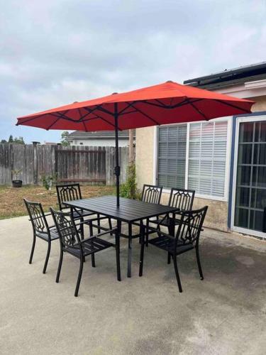 サンディエゴにある15 Min from Torrey Pines State Beach and Golfの赤い傘付きテーブルと椅子
