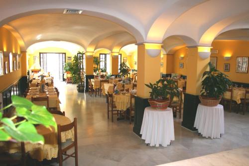 a restaurant with tables and chairs with plants on tables at MH HOTEL VARAZZE in Varazze