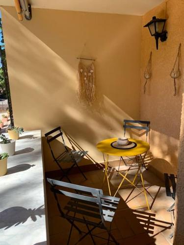 une table et des chaises jaunes dans une pièce dans l'établissement Charmant T2 rénové proche plage et commerces, à Bormes-les-Mimosas