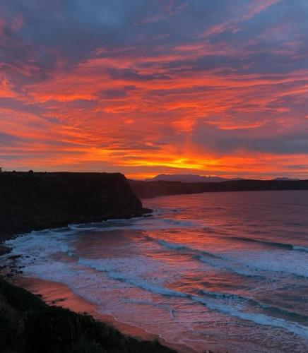 a sunset over a beach with the ocean at La Casita de Suances 2 Ideal Familias y Mascotas in Suances