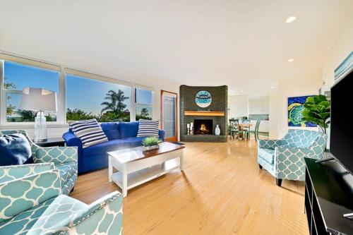 a living room with blue couches and a fireplace at Ocean Views Walk to the Beach with King Suite in Encinitas