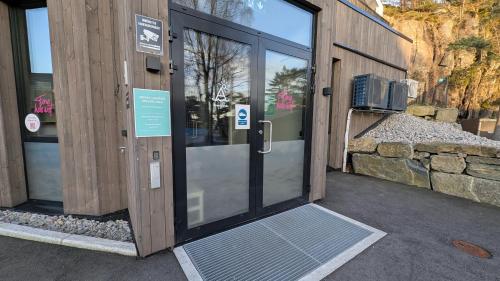 an entrance to a building with a glass door at Åros Seaside Apartment with Pool, Jacuzzi & Sauna in Kristiansand
