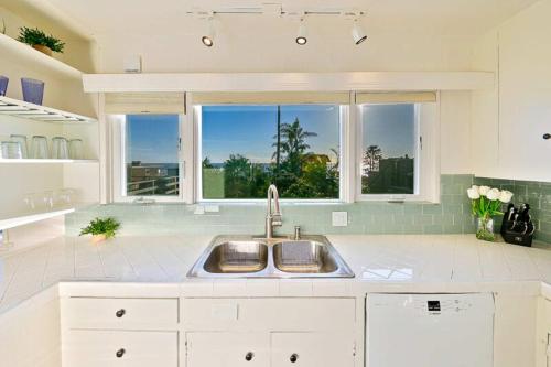 a kitchen with a sink and two windows at Ocean Views Walk to the Beach with King Suite in Encinitas
