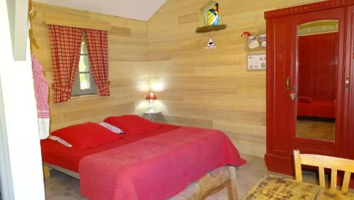 a bedroom with a bed with red sheets and a window at Chambres d'hôtes La Combe de Redoles in Tour-de-Faure