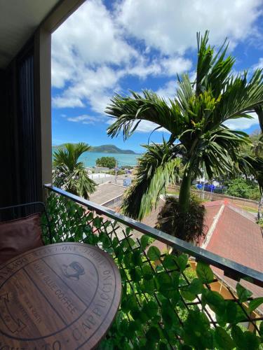 a balcony with a view of a palm tree and the ocean at Kannika saweet home in Ban Ao Makham