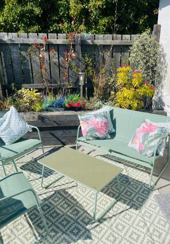 a patio with a table and two chairs and flowers at Seaview Cottage Bute in Ascog