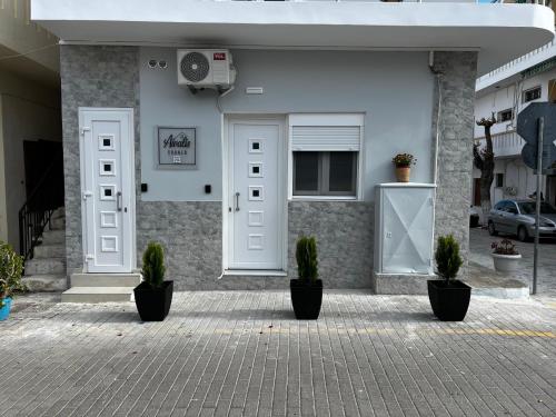 a house with potted plants in front of a door at Aivalis corner in Ierápetra