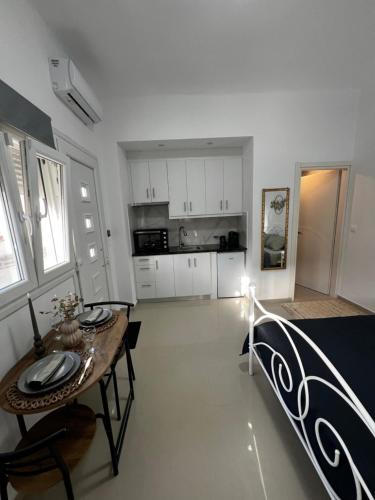 a living room with a table and a kitchen at Aivalis corner in Ierápetra