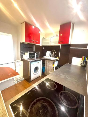 une petite cuisine avec une cuisinière et un micro-ondes dans l'établissement Apt Chic with view on Collines de Marcel Pagnol Wifi free parking and clim, à Marseille