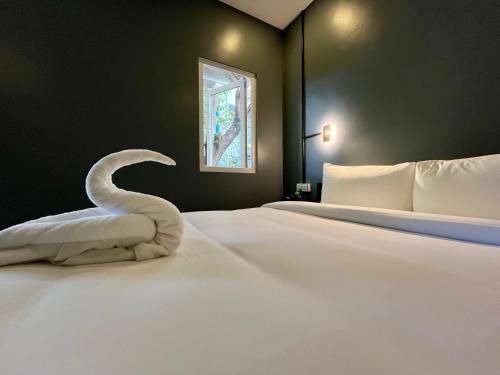 a bedroom with a bed with a swan towel on it at River Nest Hostel in Kampot