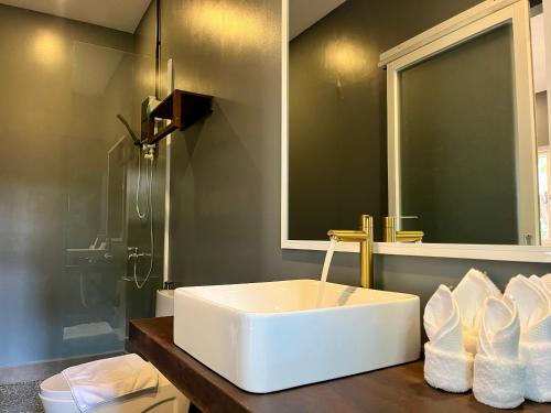 a bathroom with a white sink and a mirror at River Nest Hostel in Kampot