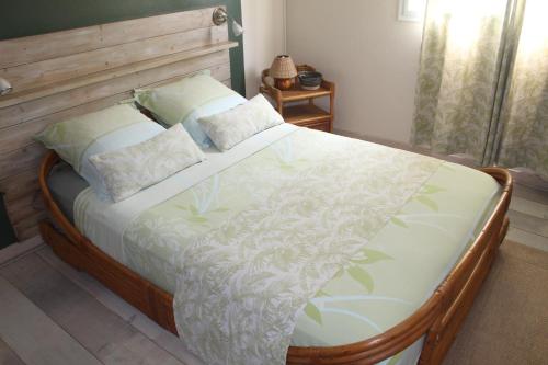 una camera da letto con un letto grande con testiera in legno di LE RUBINJO 2 a Saint-Benoît
