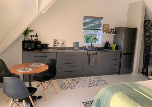 una cucina con un lavello, un tavolo e delle sedie di The Studio in Knysna a Knysna