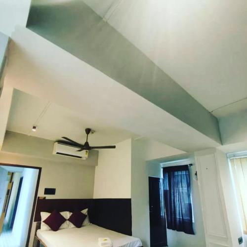 a bedroom with a ceiling fan and a bed at Blooming Rooms in Guwahati
