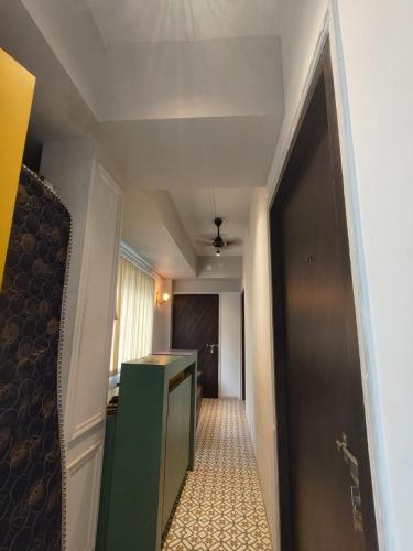 a hallway with a green door and a room at Blooming Rooms in Guwahati