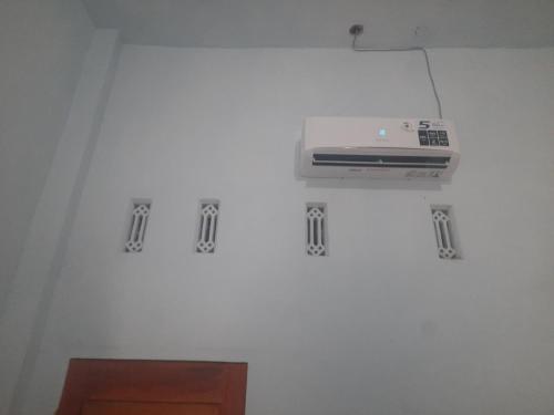 a room with a white wall with a printer on it at Ayunda Stay & Hostel in Airsatang