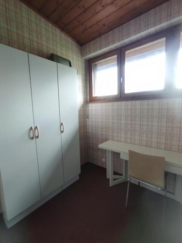 une pièce avec une table, des armoires et une fenêtre dans l'établissement Appartement f1 en maison calme, à Amancy