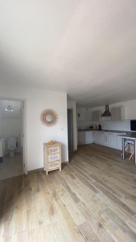 - un salon vide avec des murs blancs et du parquet dans l'établissement Le Petit paradis, à Aregno