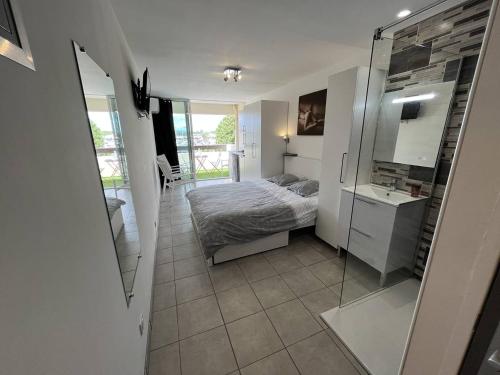 une chambre avec un lit et une douche en verre dans l'établissement Studio 2 couchage Cap d'Agde Naturisme CN040-633, au Cap d'Agde