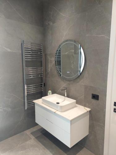 a bathroom with a white sink and a mirror at Vila Palma in Berat