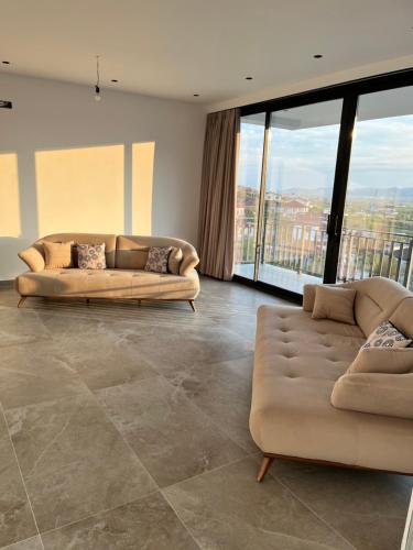 a living room with two couches and large windows at Vila Palma in Berat